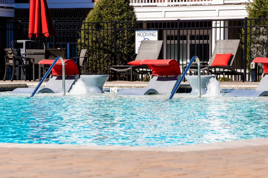 Proximity Northlake Swimming pool with lounge chairs, water jets, and "No Diving" sign near a fenced patio area.
