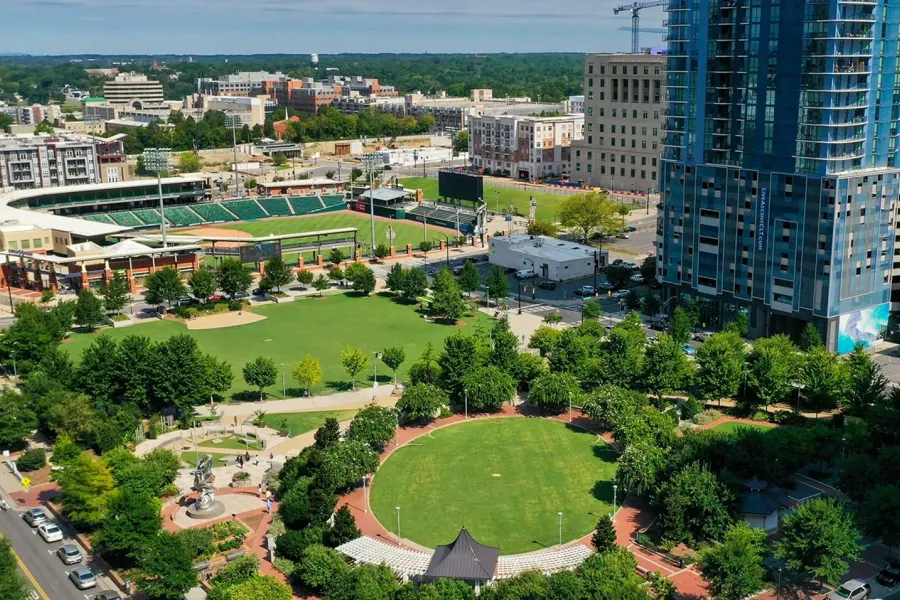 Proximity Northlake Aerial view of a city park with green lawns, trees, and surrounding high-rise buildings.