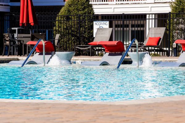 Proximity Northlake Swimming pool with lounge chairs, water jets, and "No Diving" sign near a fenced patio area.