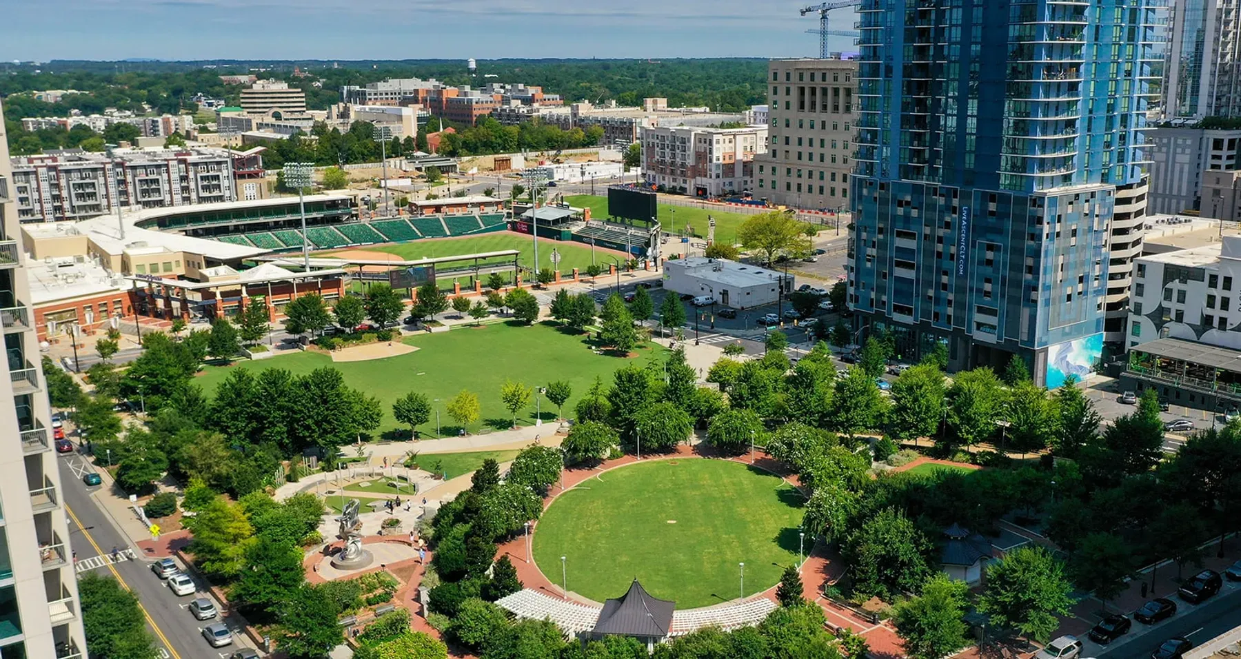 Proximity Northlake Aerial view of a city park with green lawns, trees, and surrounding high-rise buildings.